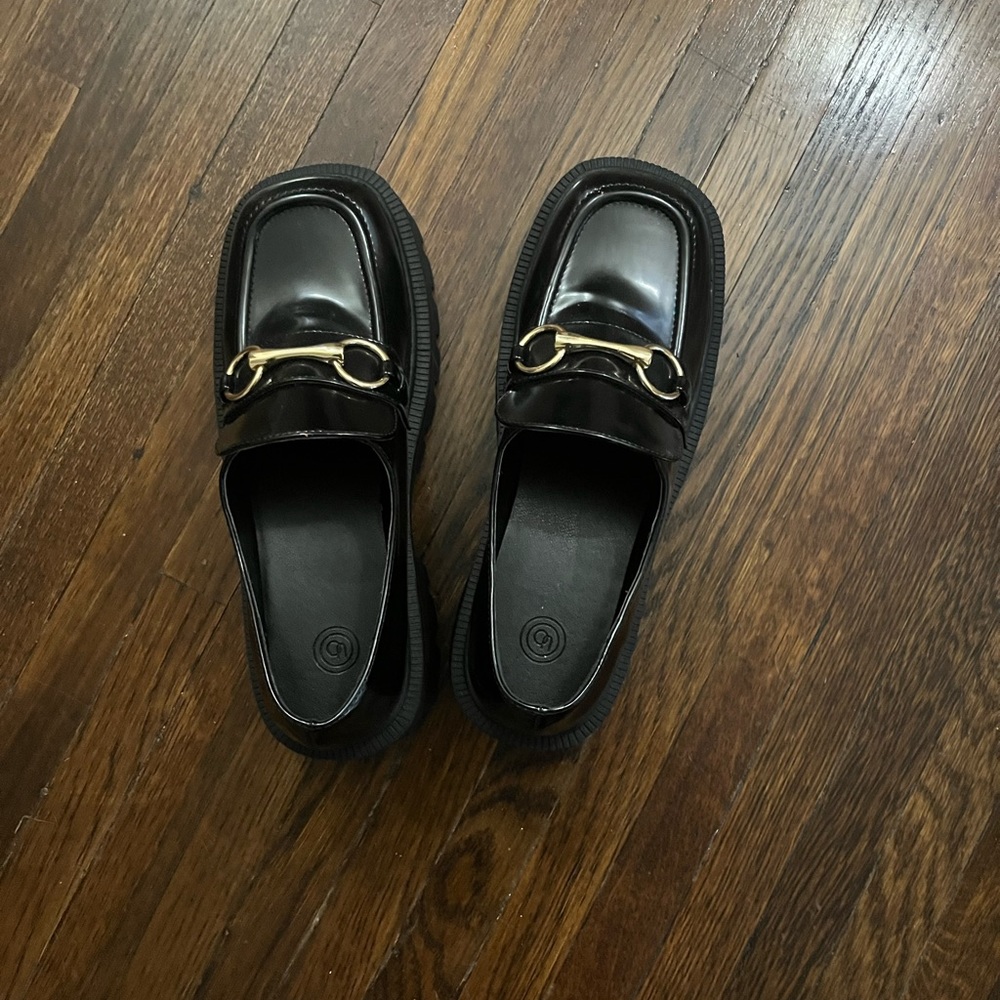 Black loafers with gold hardware